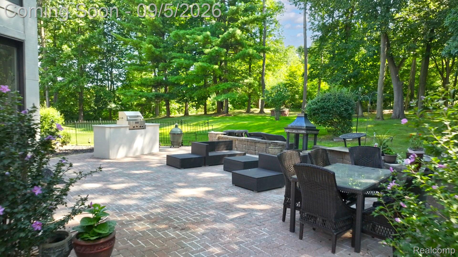 2785 Cranbrook Ridge Court Rochester, MI 48306 - Photo 81 of 97 Paver patio featuring an outdoor kitchen with built-in grill, stone fire pit, and lush green landscaping