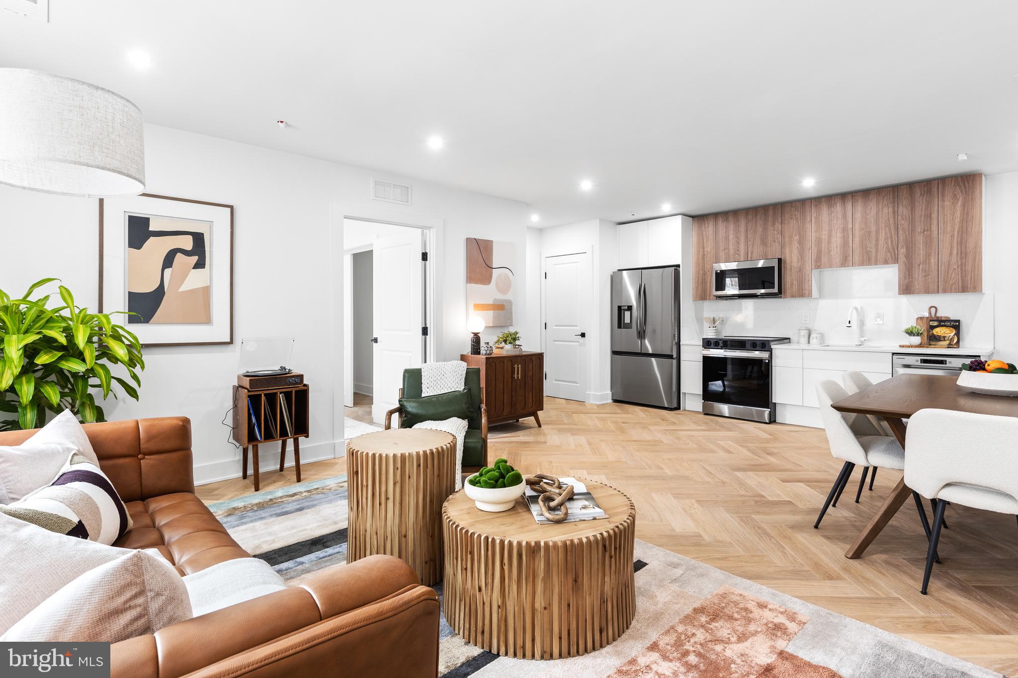 a living room with furniture a fireplace and a kitchen view