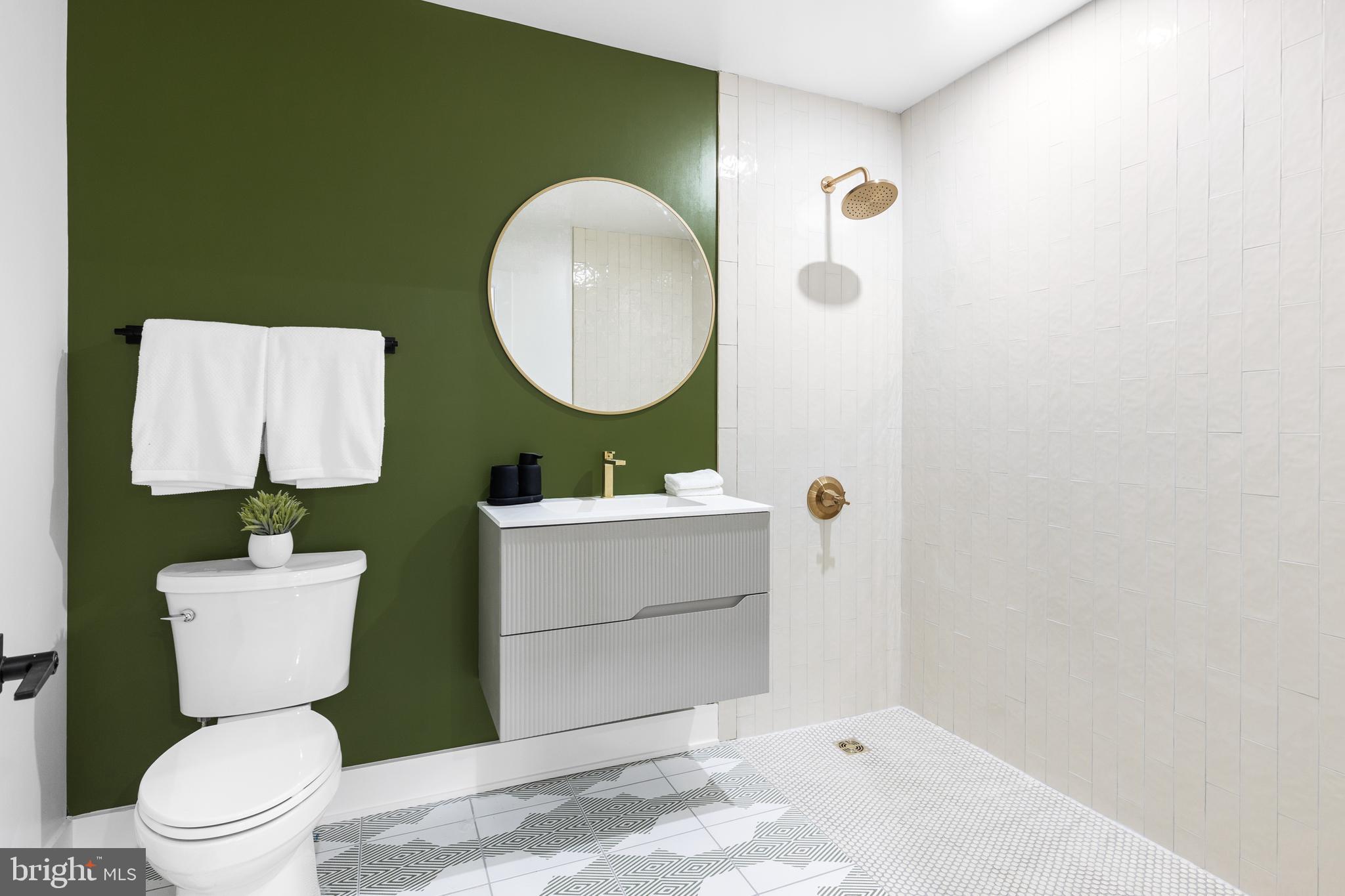 1124 Florida Street Northeast, Unit 210 Washington, DC 20002 - Photo 15 of 26 a bathroom with a toilet sink mirror and vanity