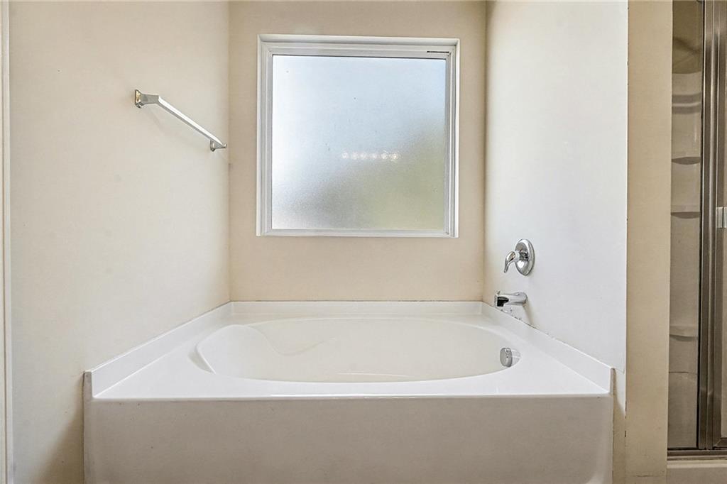 11046 Genova Terrace Hampton, GA 30228 - Photo 20 of 38 a white bath tub sitting next to a white sink and vanity