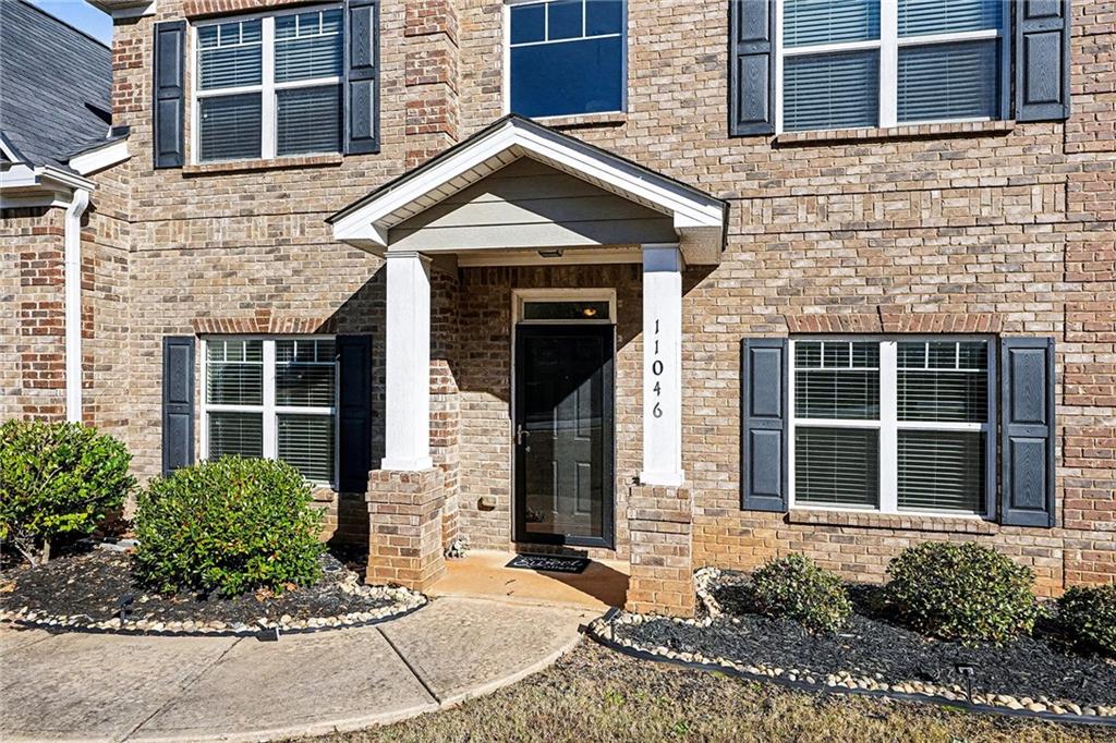 11046 Genova Terrace Hampton, GA 30228 - Photo 4 of 38 a front view of a brick house with a yard and windows