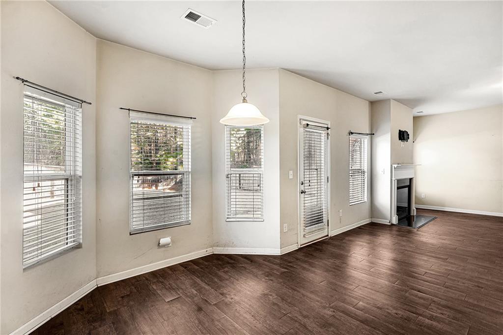 11046 Genova Terrace Hampton, GA 30228 - Photo 7 of 38 a view of an empty room with wooden floor and a window