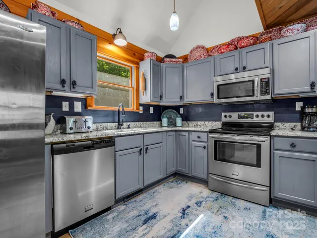 a kitchen with stainless steel appliances granite countertop a stove a sink and a microwave