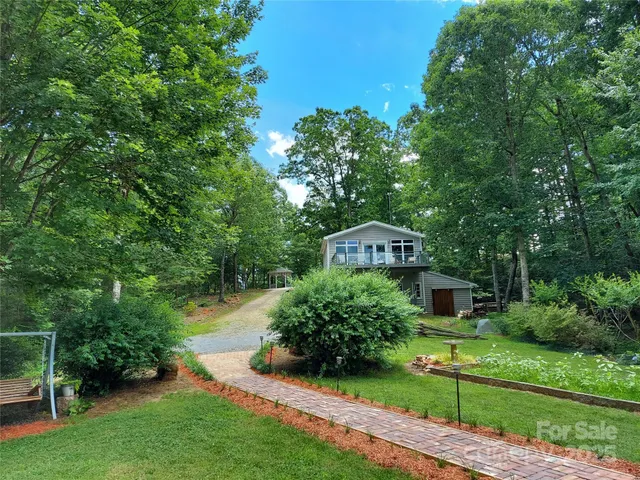 a front view of a house with a yard and trees