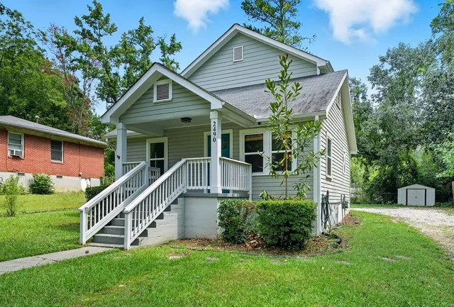 a front view of house with a yard and potted plants