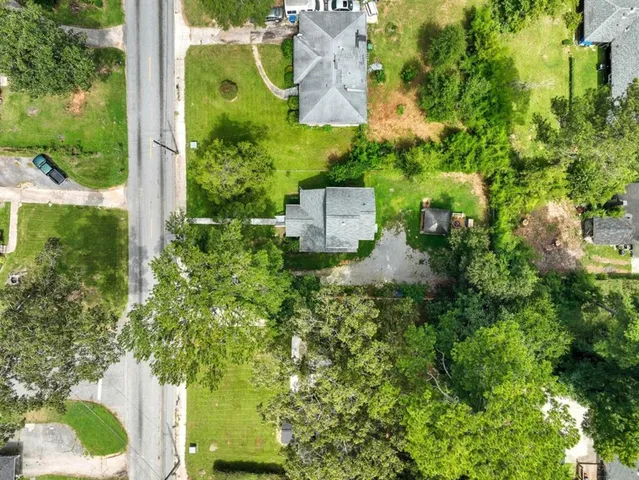 an aerial view of residential house with outdoor space and trees all around