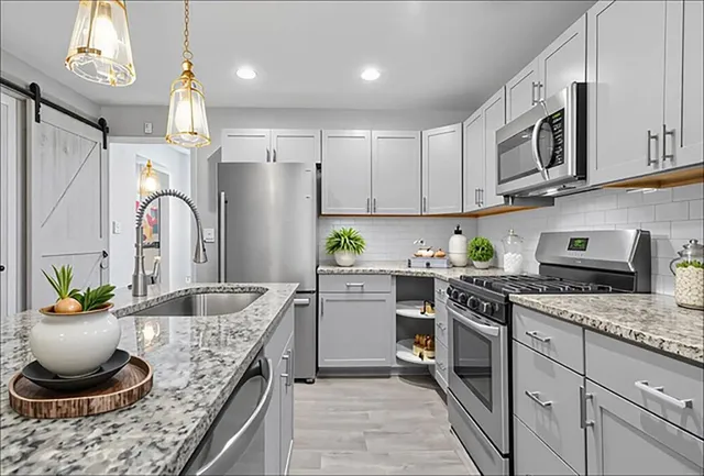 a kitchen with granite countertop a sink stainless steel appliances and cabinets