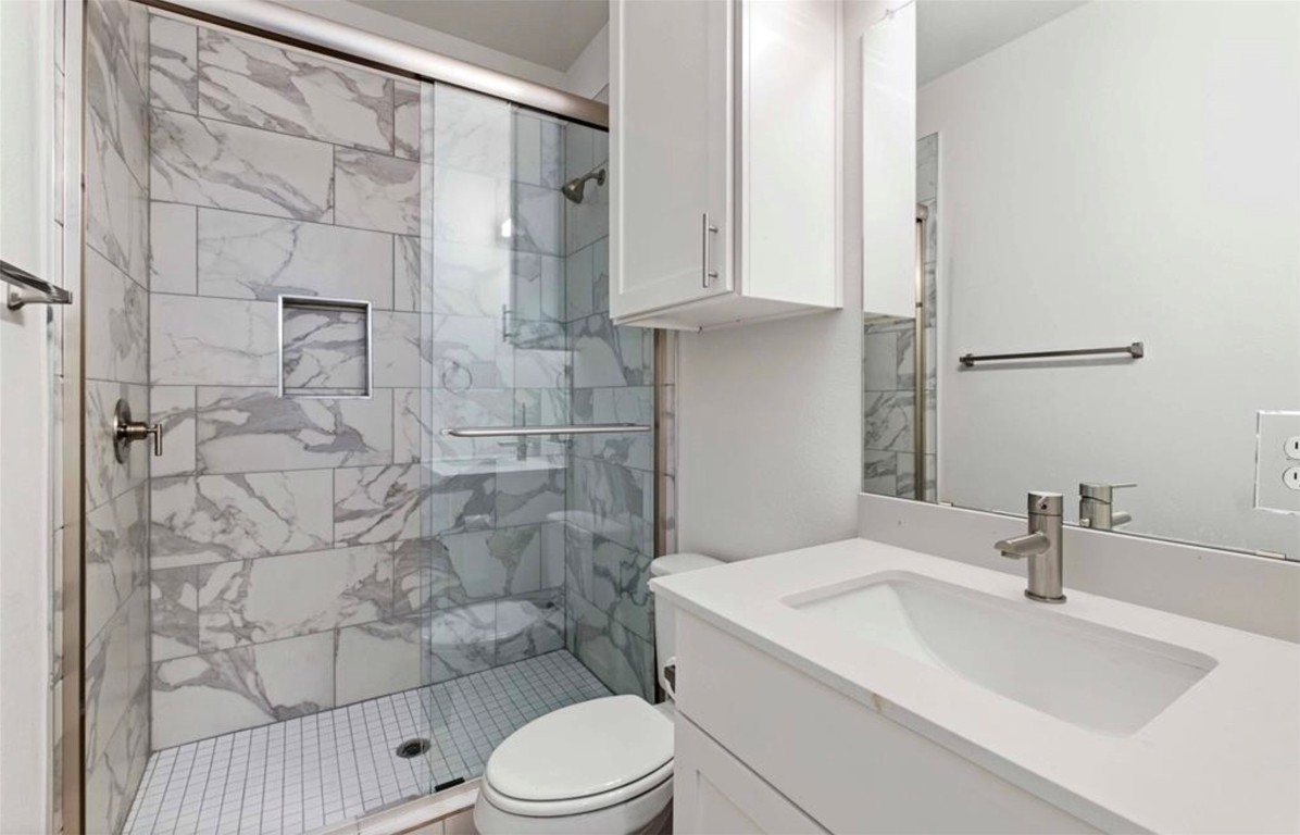 7407 Bethune Avenue, Unit 2 Austin, TX 78752 - Photo 23 of 30 a bathroom with a sink a toilet and shower