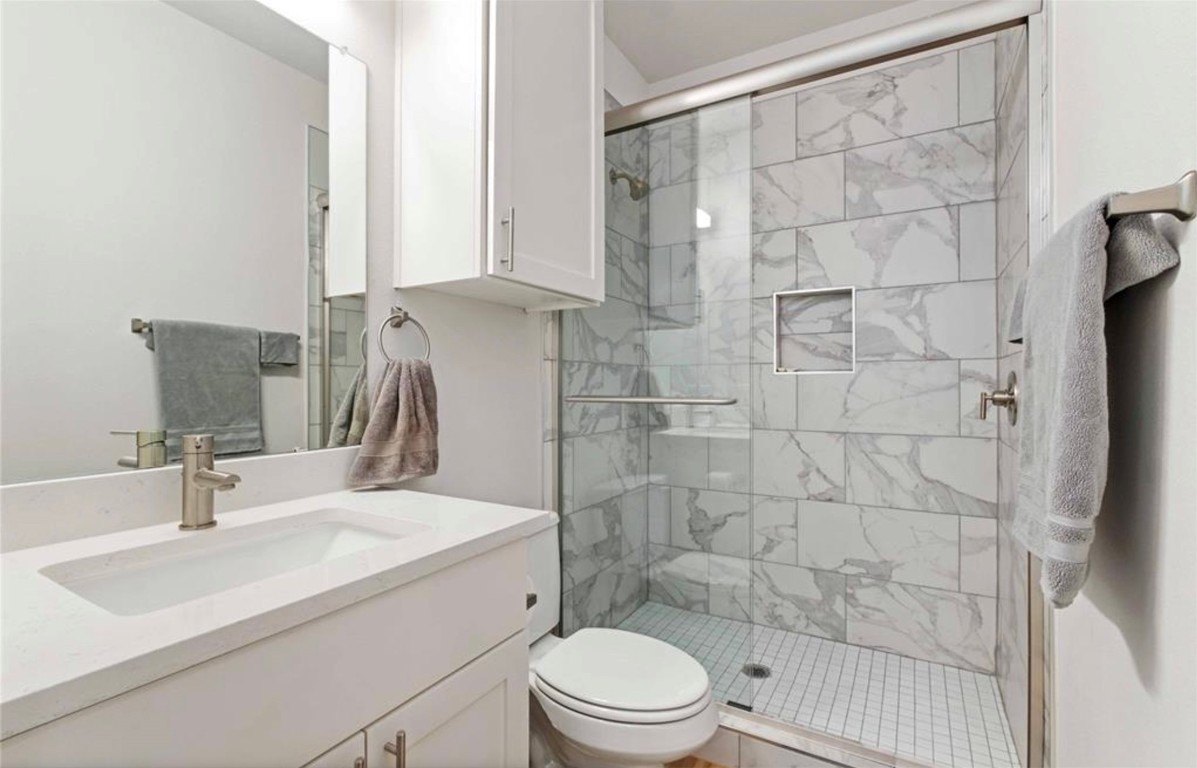 7407 Bethune Avenue, Unit 2 Austin, TX 78752 - Photo 26 of 30 a bathroom with a sink toilet a mirror and shower