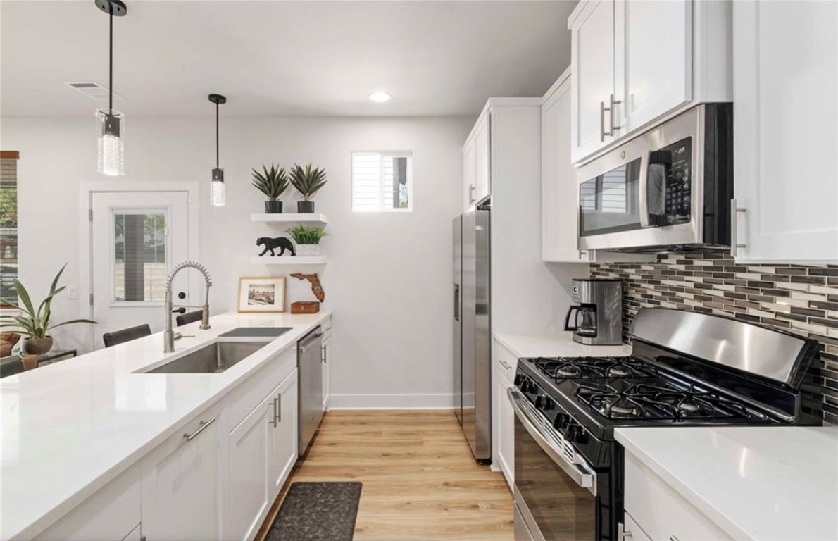 7407 Bethune Avenue, Unit 2 Austin, TX 78752 - Photo 10 of 30 a kitchen with stainless steel appliances granite countertop a sink stove and refrigerator