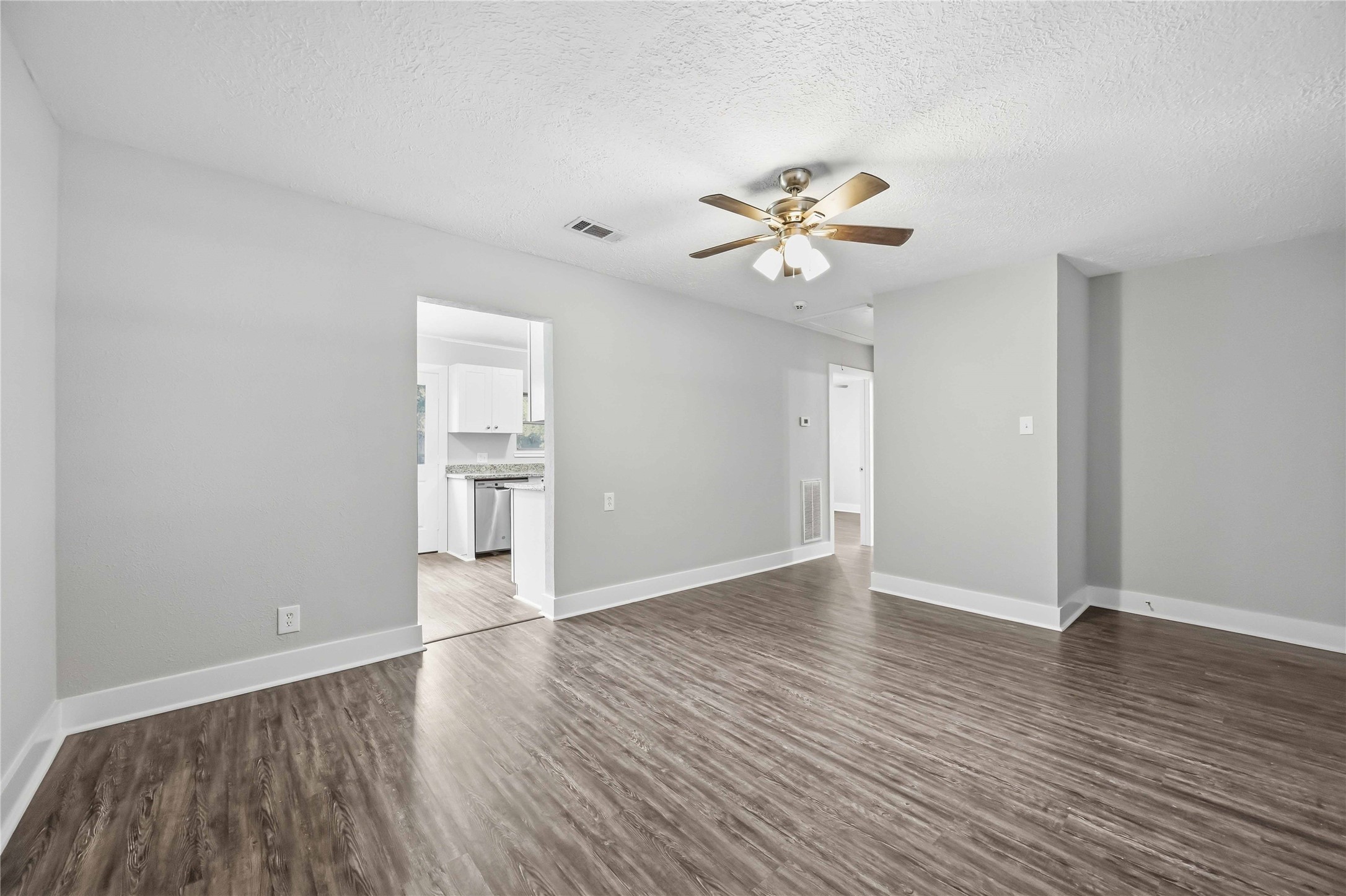 113 East Witcher Lane Houston, TX 77076 - Photo 7 of 21 an empty room with wooden floor and a ceiling fan