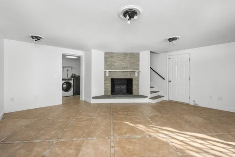 a view of an empty room with a fireplace and a window