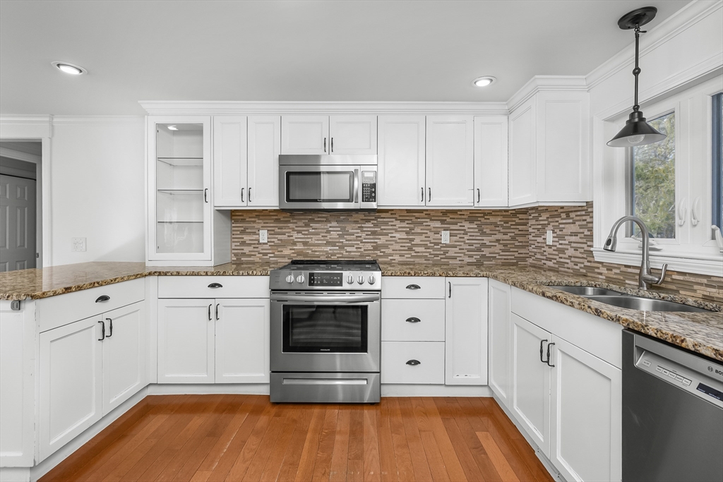 103 Pine Tree Drive Barnstable, MA 02632 - Photo 9 of 42 a kitchen with stainless steel appliances granite countertop a stove and white cabinets