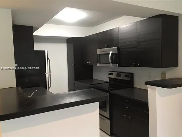 a kitchen with a refrigerator and a stove top oven