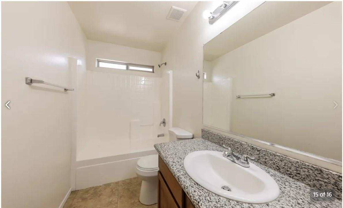 12563 West Charter Oak Road El Mirage, AZ 85335 - Photo 15 of 16 a bathroom with a granite countertop sink a toilet and shower