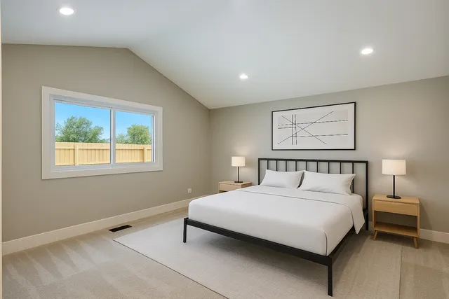 a large bedroom with a bed and a painting on the wall