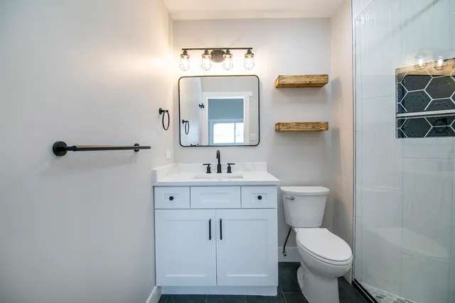 a bathroom with a toilet sink and mirror
