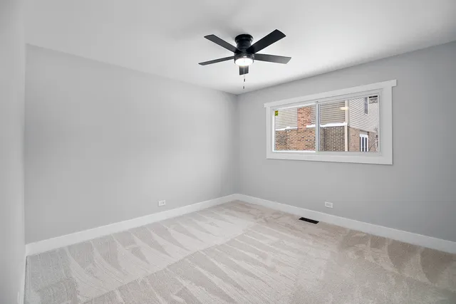 a view of a big room with wooden floor and windows