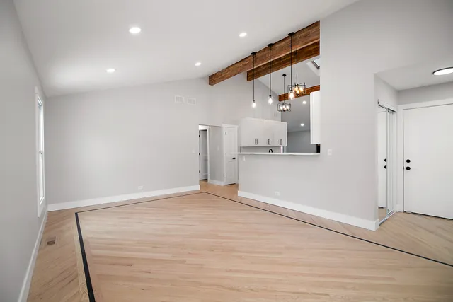 en empty room with wooden floor and windows