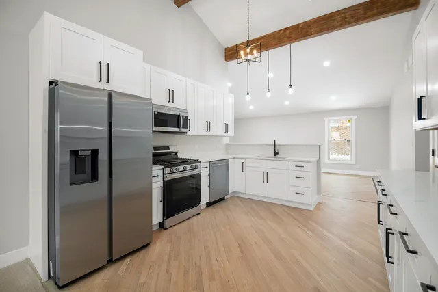a kitchen with stainless steel appliances a refrigerator sink and microwave