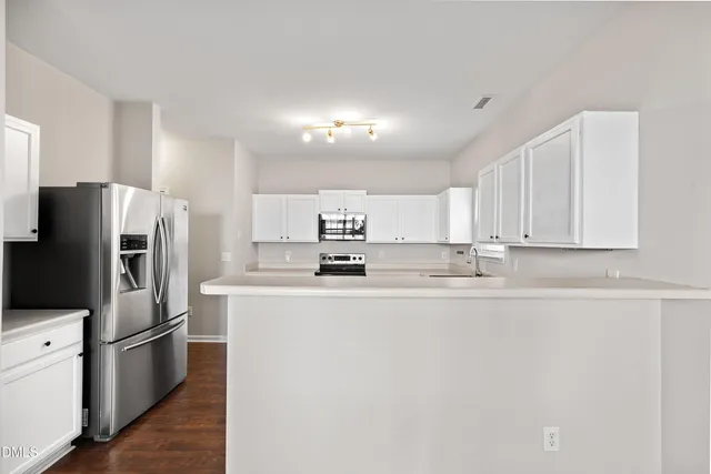 a view of a kitchen with wooden floor and a large window
