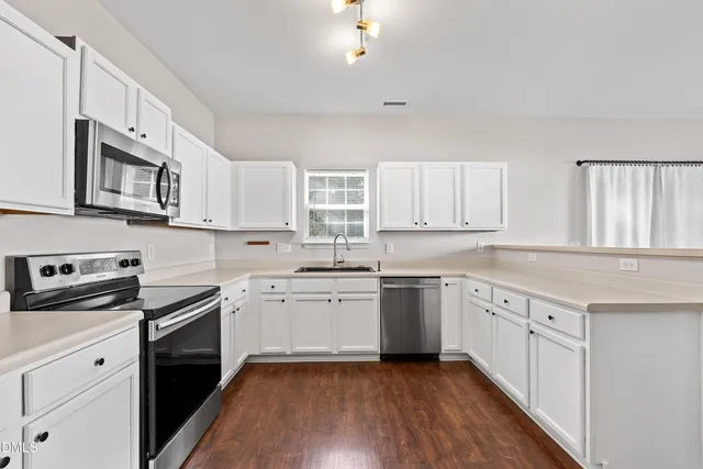 a kitchen with stainless steel appliances a refrigerator sink and microwave