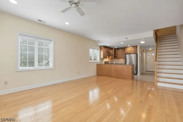 a view of a livingroom with furniture an empty room and kitchen view