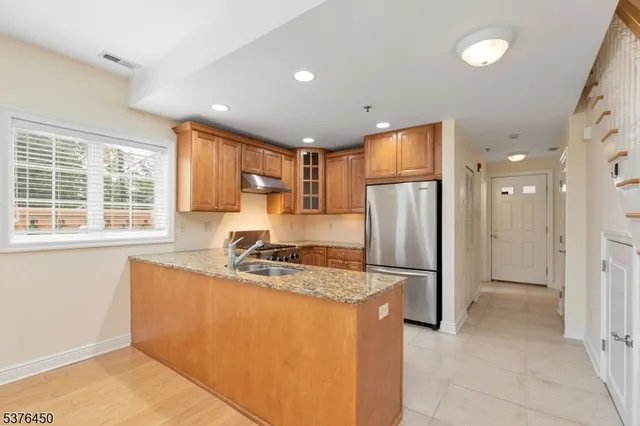 a kitchen with stainless steel appliances granite countertop a refrigerator stove and sink