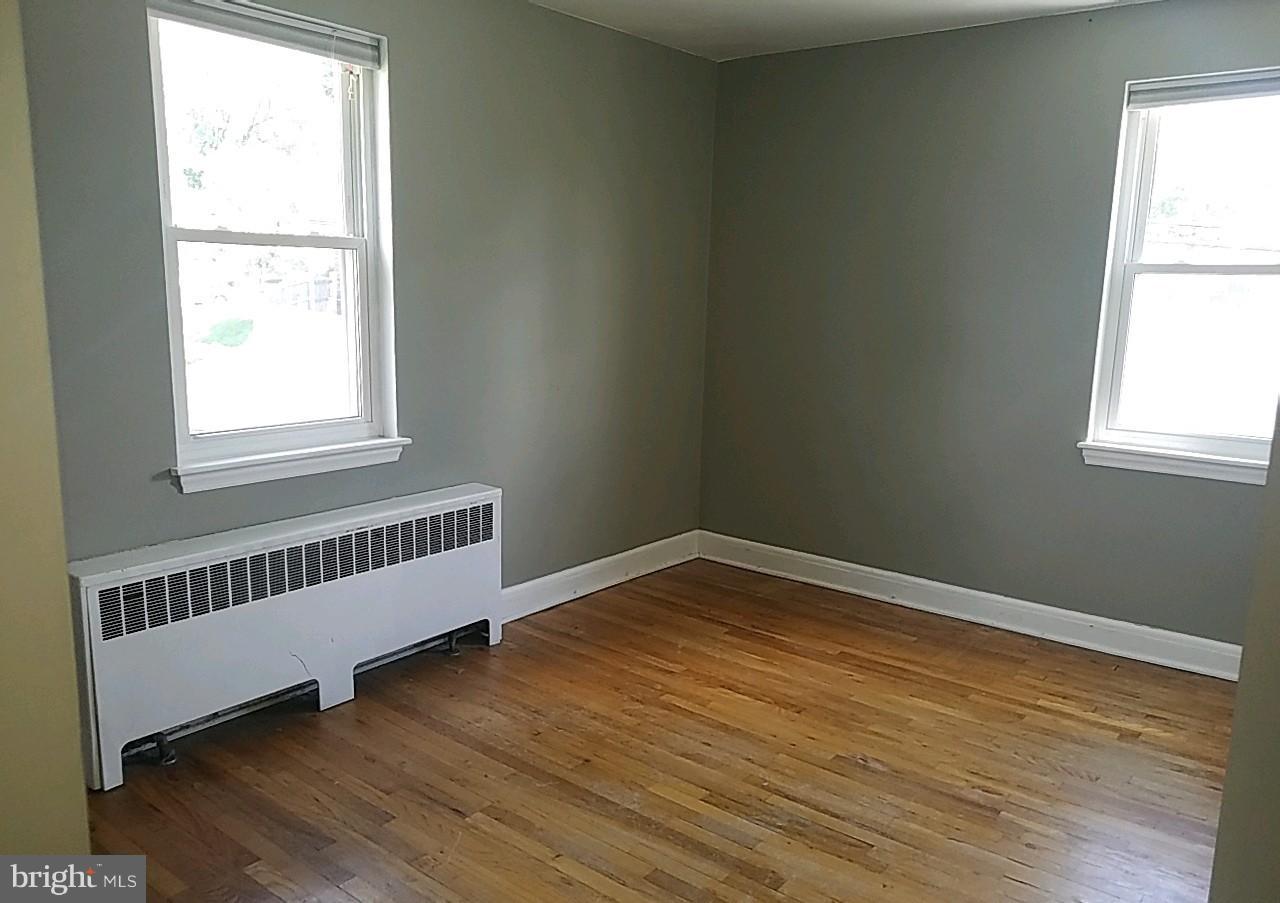 8539 Willow Oak Road Baltimore, MD 21234 - Photo 22 of 30 an empty room with wooden floor and windows