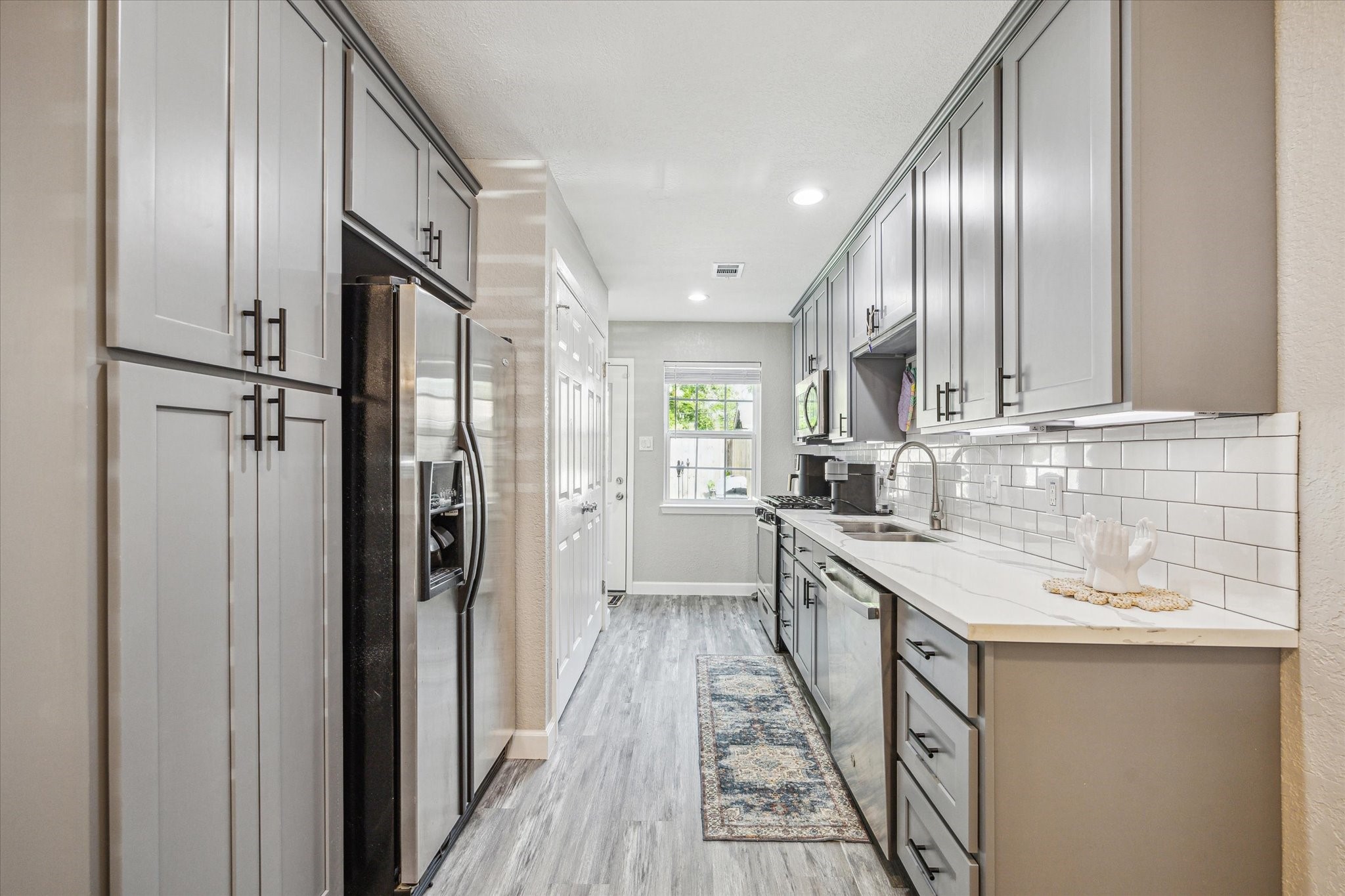 3808 Cochran Street Houston, TX 77009 - Photo 6 of 14 a kitchen with stainless steel appliances granite countertop a sink and refrigerator