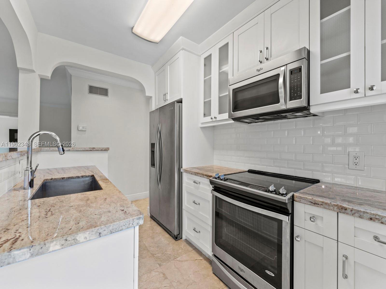 5940 Southwest 47th Street Miami, FL 33155 - Photo 19 of 53 a kitchen with granite countertop white cabinets and stainless steel appliances