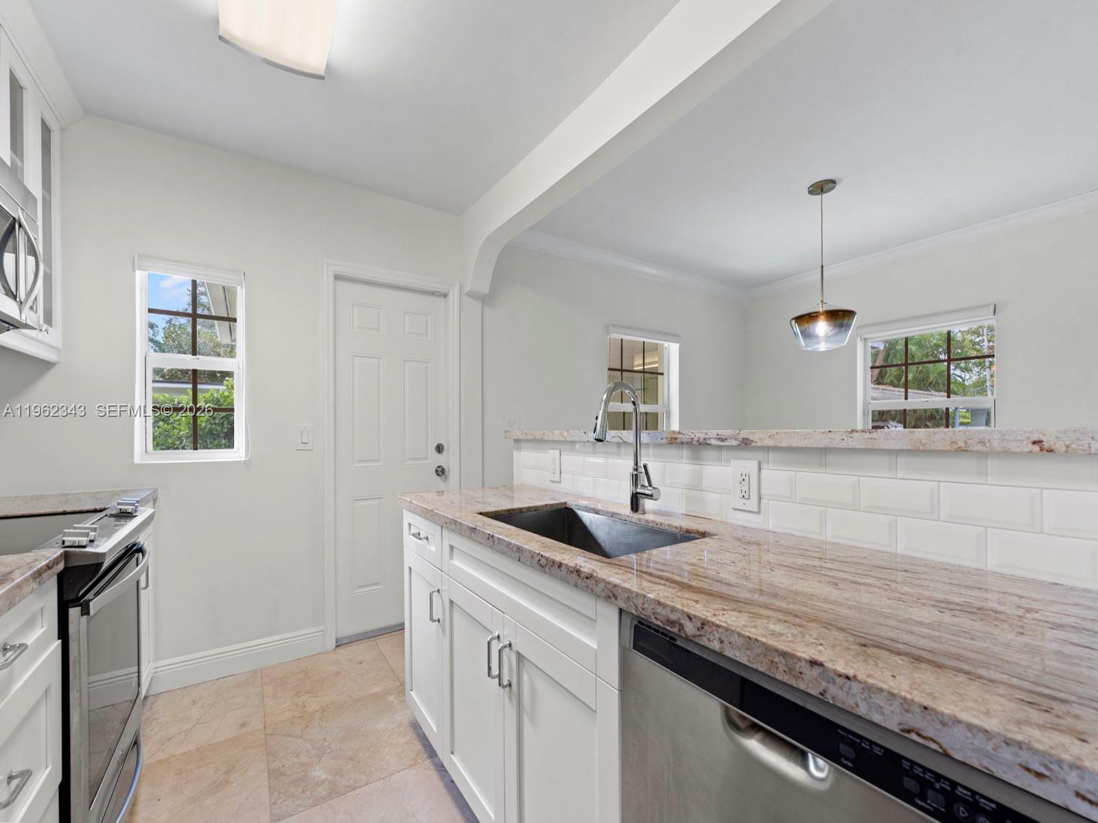 5940 Southwest 47th Street Miami, FL 33155 - Photo 20 of 53 a kitchen with granite countertop a sink and a window