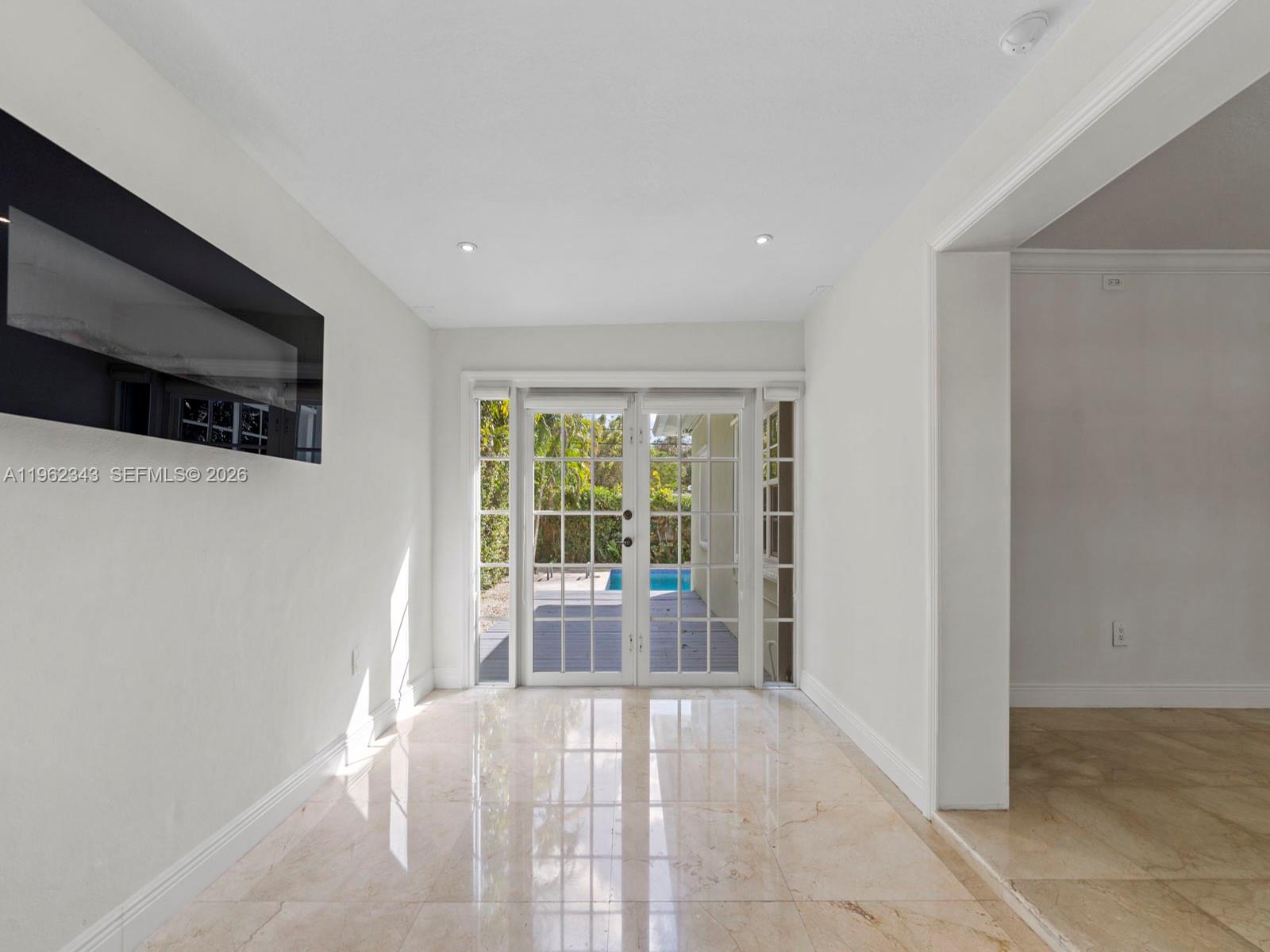 5940 Southwest 47th Street Miami, FL 33155 - Photo 27 of 53 a view of an empty room with wooden floor and a window
