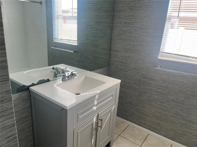 a bathroom with a sink a vanity and a window