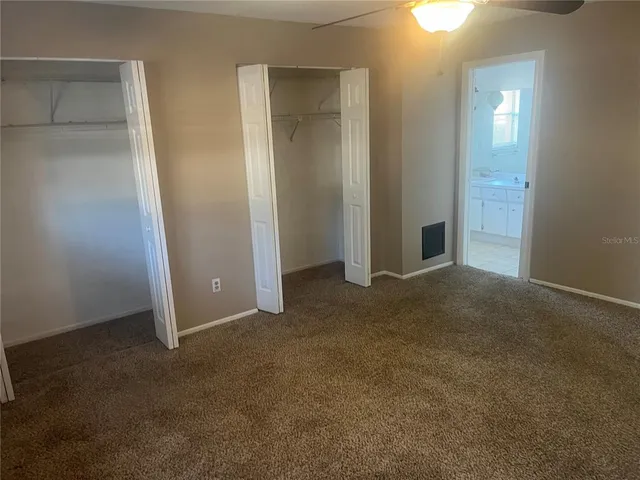 an empty room with closet and mirror