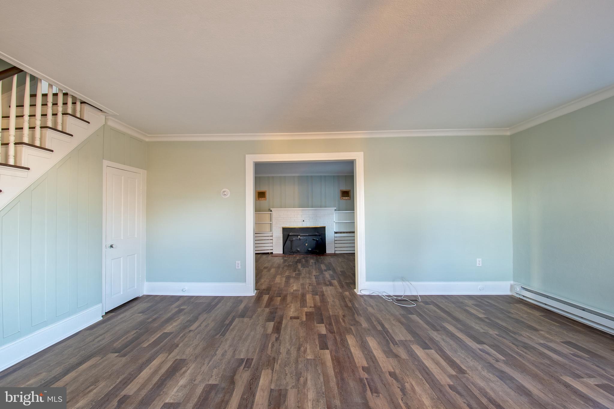 25165 Prettyman Road Georgetown, DE 19947 - Photo 11 of 43 a view of a room with wooden floor staircase and a kitchen