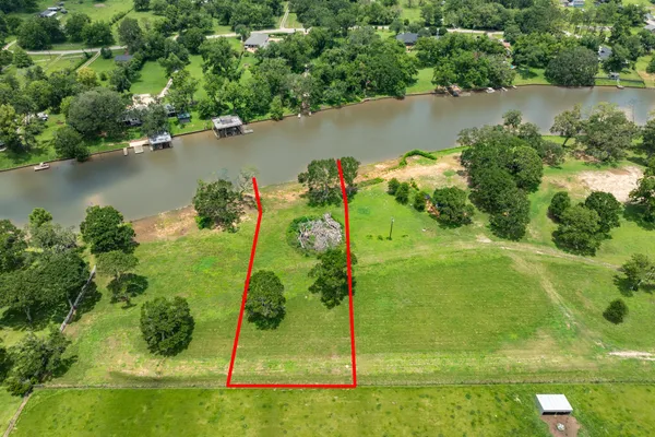 an aerial view of a houses with a yard and lake view