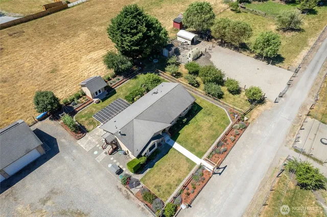 an aerial view of a house with a yard and lake