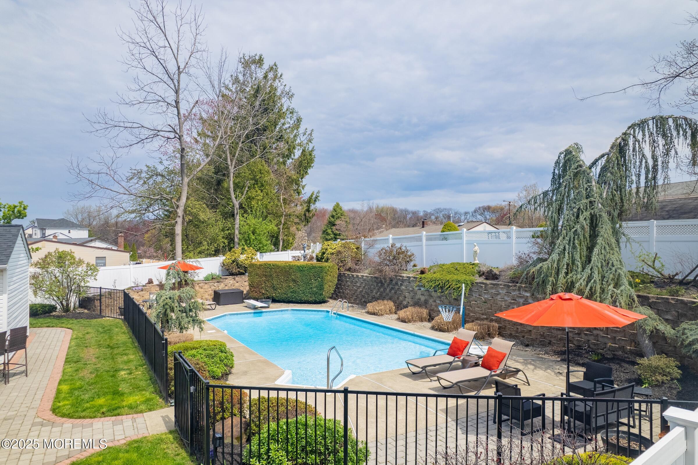 22 A Bedle Road Hazlet, NJ 07730 - Photo 23 of 32 a view of a patio with couches table and chairs under an umbrella with a fire pit