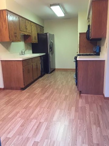 250 Circlegate Road, Unit 250 New Lenox, IL 60451 - Photo 9 of 25 a kitchen with stainless steel appliances a refrigerator and a wooden floor