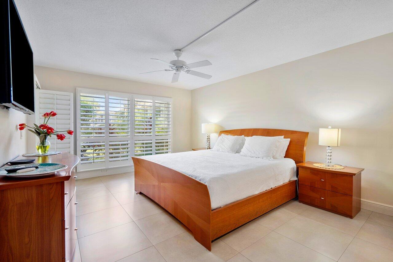 3677 Quail Ridge Drive, Unit BOBWHITE B Boynton Beach, FL 33436 - Photo 19 of 47 a bedroom with a bed and a flat tv screen on dresser