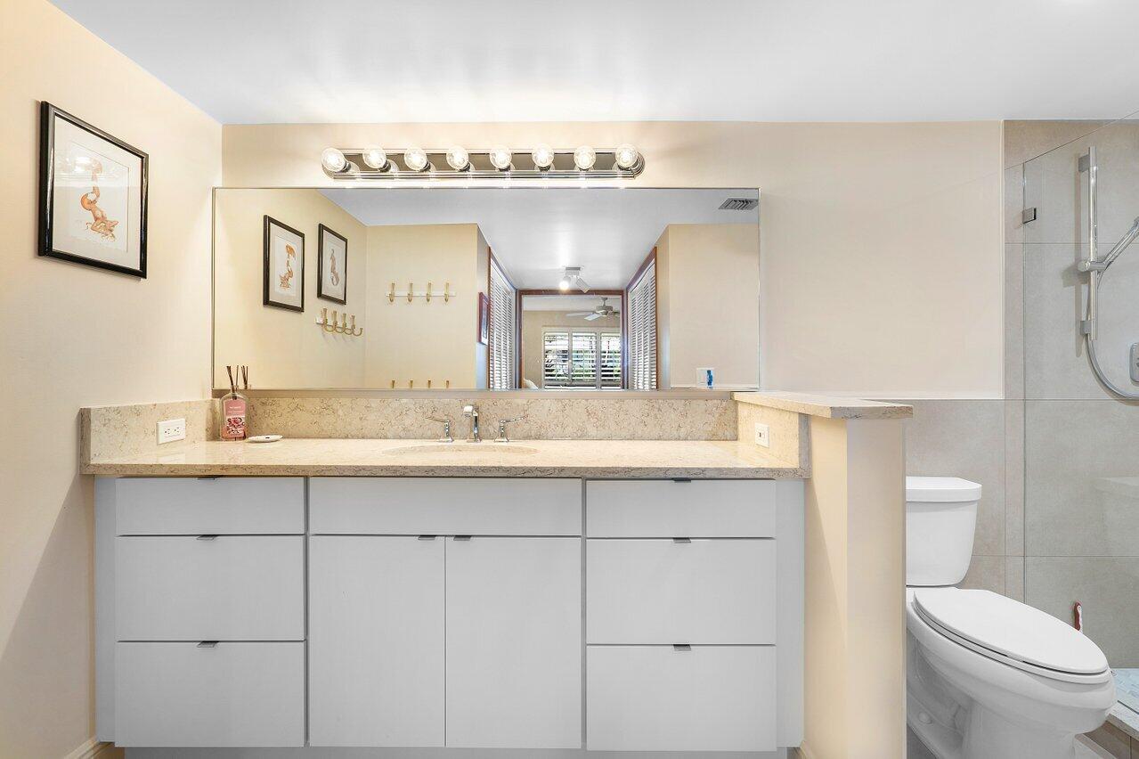 3677 Quail Ridge Drive, Unit BOBWHITE B Boynton Beach, FL 33436 - Photo 21 of 47 a bathroom with a granite countertop sink mirror and toilet