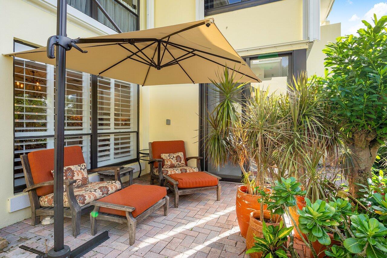 3677 Quail Ridge Drive, Unit BOBWHITE B Boynton Beach, FL 33436 - Photo 23 of 47 a backyard of a house with table and chairs