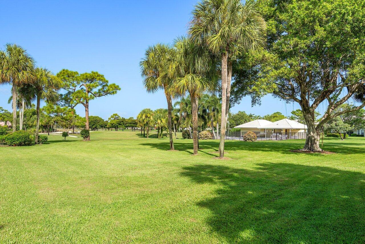 3677 Quail Ridge Drive, Unit BOBWHITE B Boynton Beach, FL 33436 - Photo 26 of 47 a backyard of a house with table and chairs