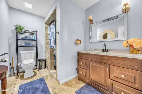 a bathroom with a granite countertop toilet sink and mirror