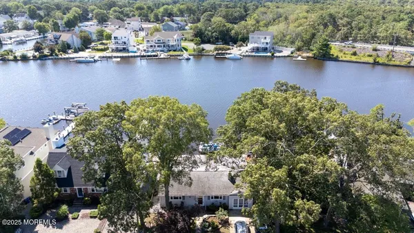 an aerial view of residential houses with outdoor space and lake view