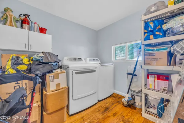 a view of a patio with dining table and chairs with potted plants and large trees