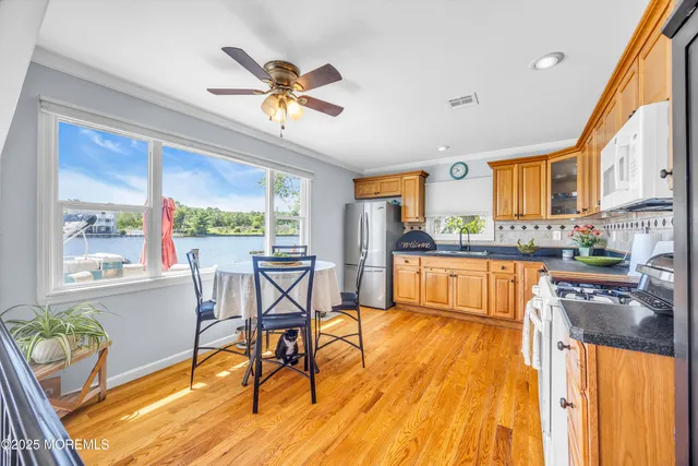 a living room with stainless steel appliances kitchen island granite countertop furniture and a large window