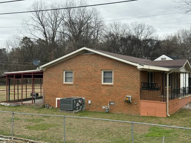 a view of a house with a yard and potted plants