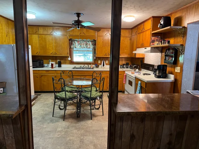 a kitchen with stainless steel appliances a stove a refrigerator a dining table and chairs